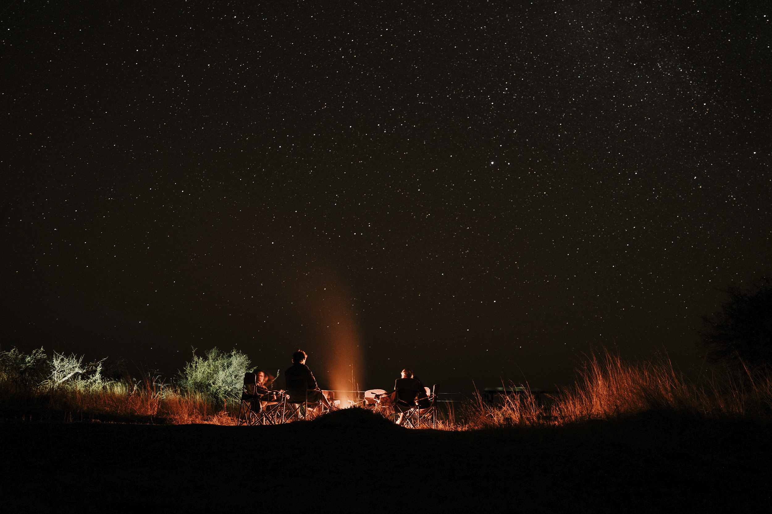 group-of-people-sitting-around-a-campfire-at-night.jpg